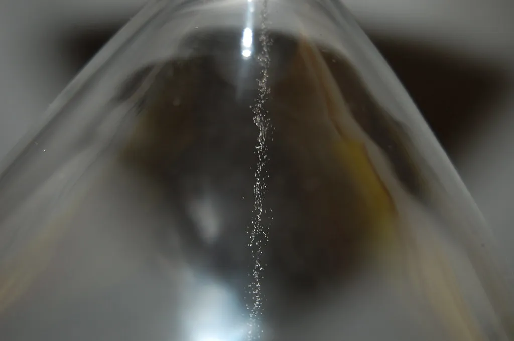 Close-up of sand falling inside an hourglass