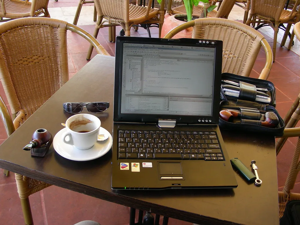 A laptop and notebook set up as a mobile workspace