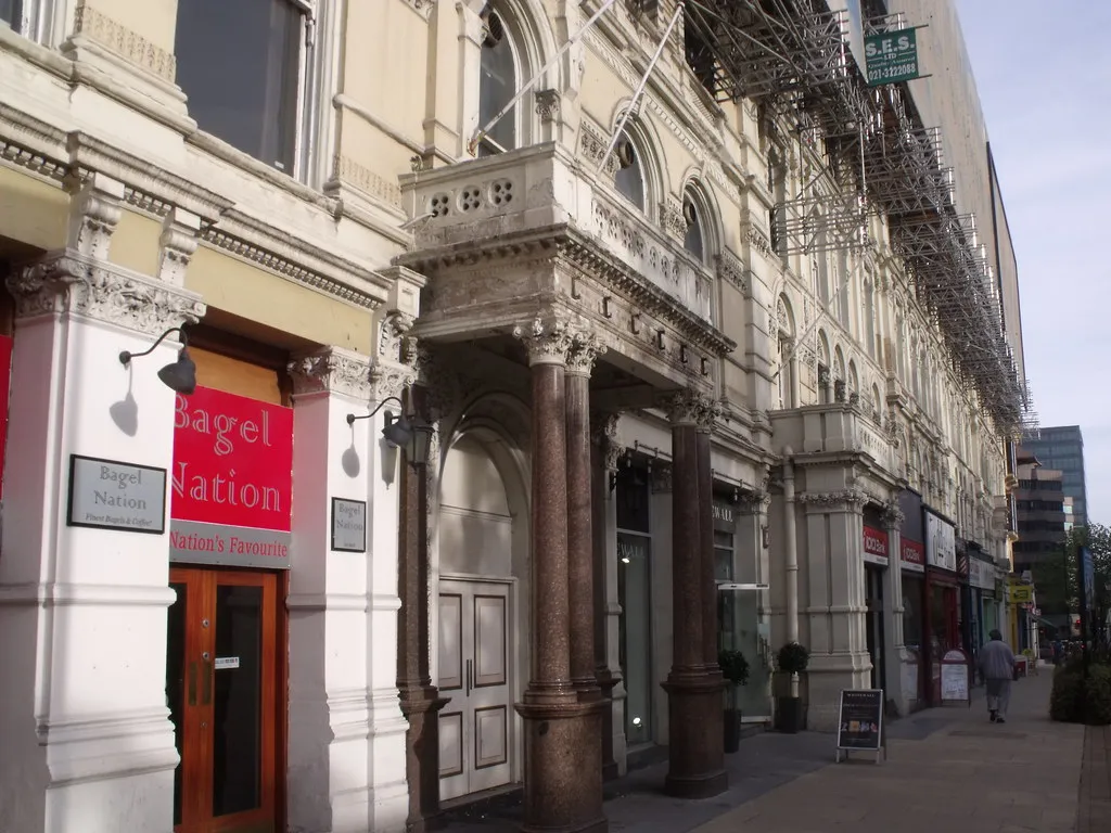 Scaffolding wrapped around the upper floors of an ornate old building