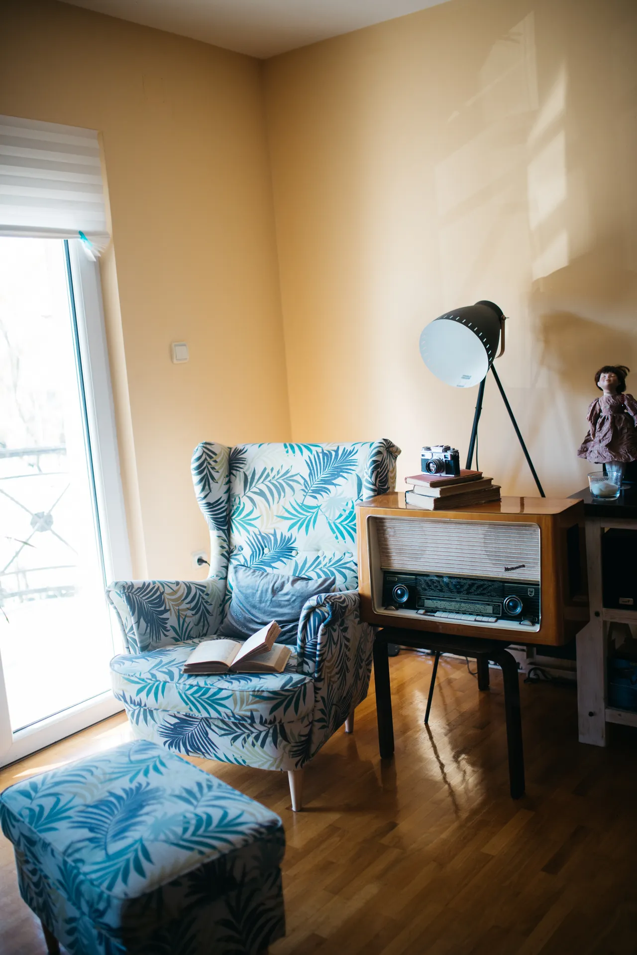 A cosy reading corner with an armchair, an open book and warm sunlight