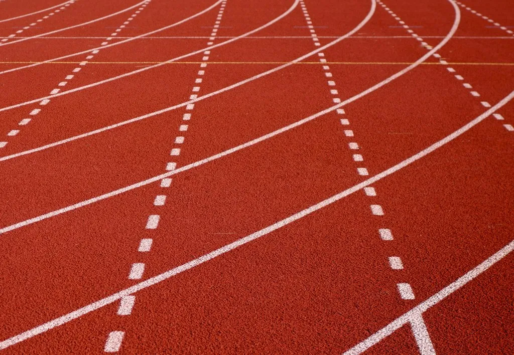 An empty outdoor running track curving into the distance