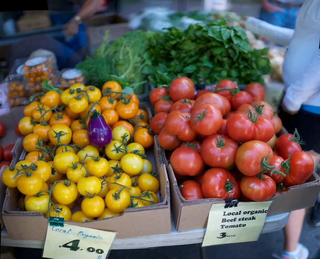 Boxes of red and yellow tomatoes at a market stall