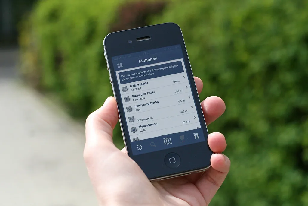 A hand holding a smartphone showing a list app
